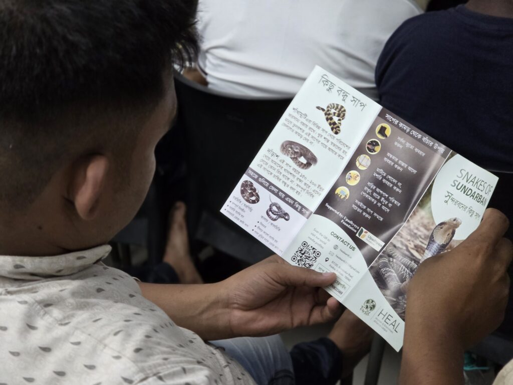 Snakebite Mitigation work starts with awareness. A villager reads pamphlet distributed by HEAL 